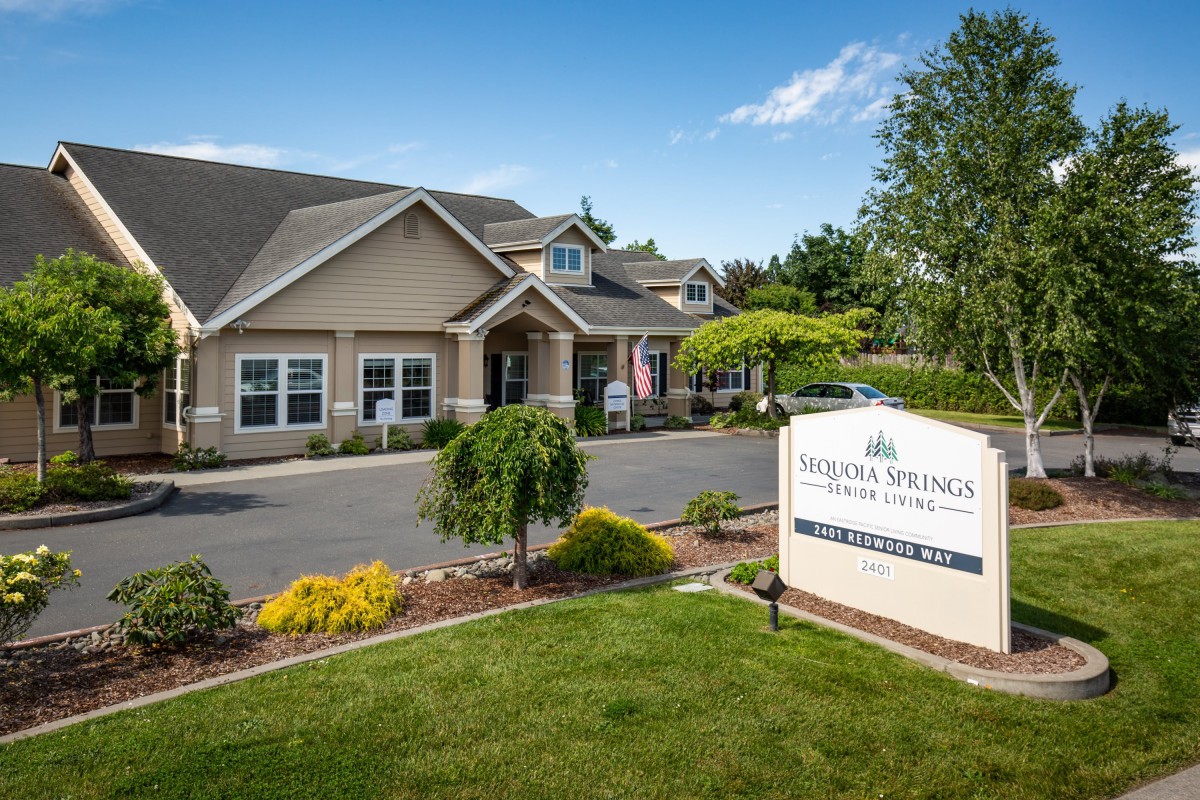 A well-maintained facility with a landscaped garden and clear signage on a sunny day.