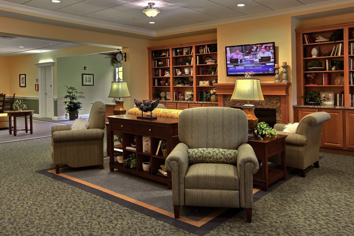 A cozy living room featuring comfortable seating, a wooden bookshelf, and a television.