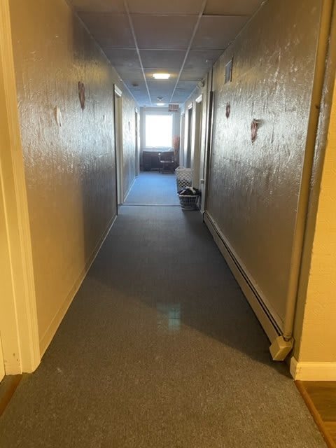 A well-lit hallway in a building with doors on each side.