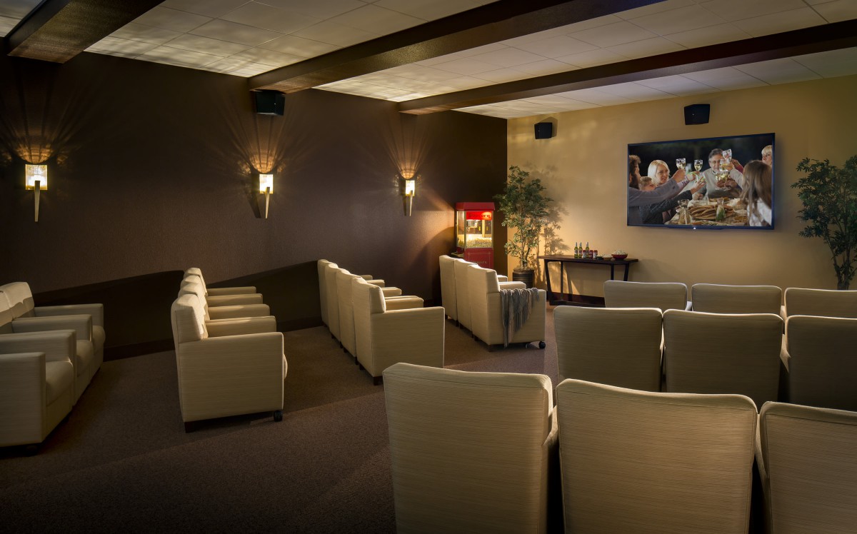 A cozy home theater with comfortable seating and a popcorn machine.