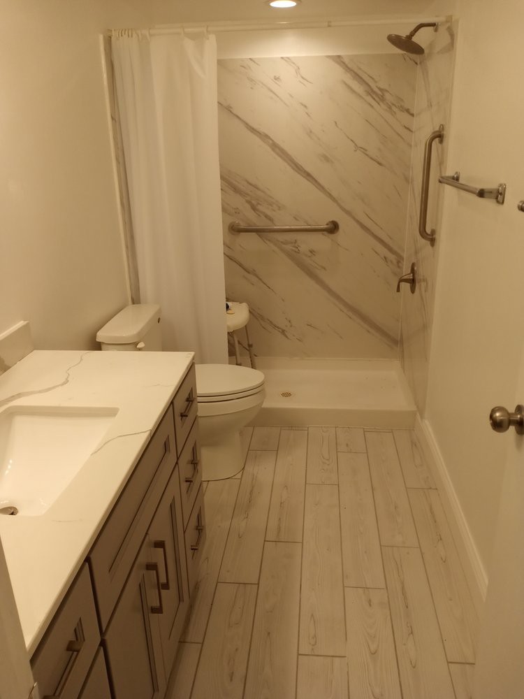A modern, clean bathroom with a shower, sink, and toilet.