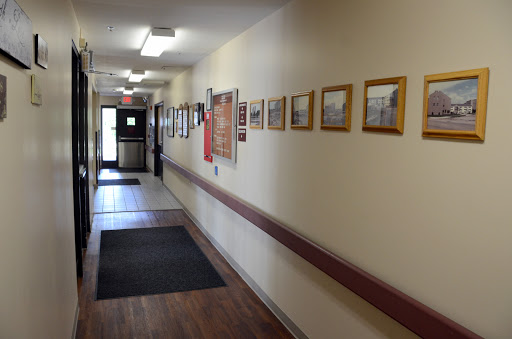 A well-lit hallway adorned with framed photographs on the wall.