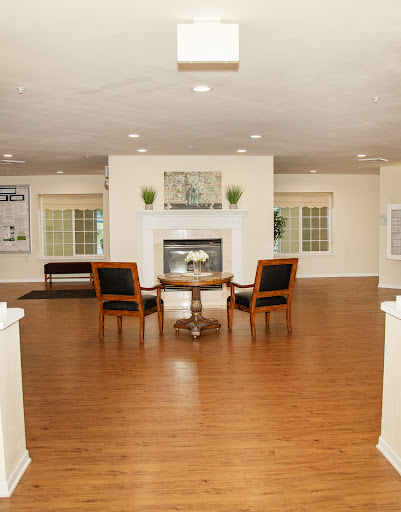 A spacious living room featuring elegant wooden flooring, cozy seating, and a welcoming fireplace.