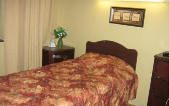 A cozy bedroom with a single bed, nightstand, and decorative elements.