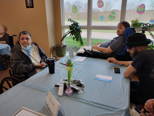 A relaxed gathering of individuals at a table, engaged in conversation in a communal space.