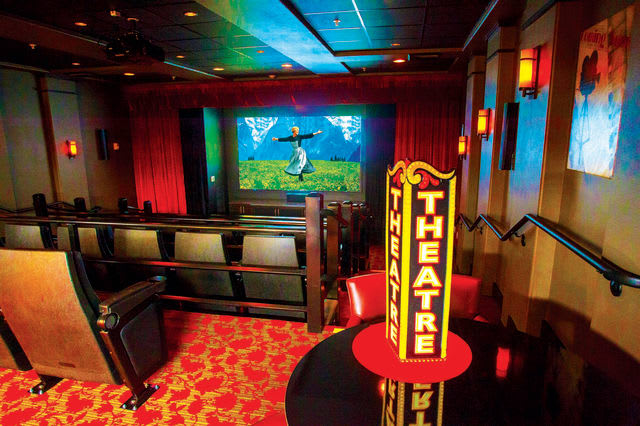 An intimate theater interior with seating and a colorful stage, ready for a performance.