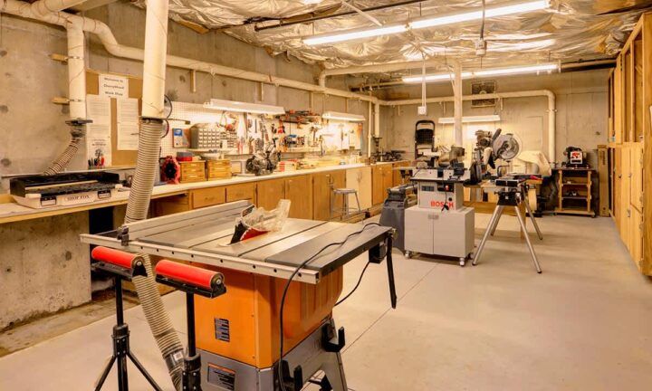 A spacious workshop filled with various woodworking machines and tools.