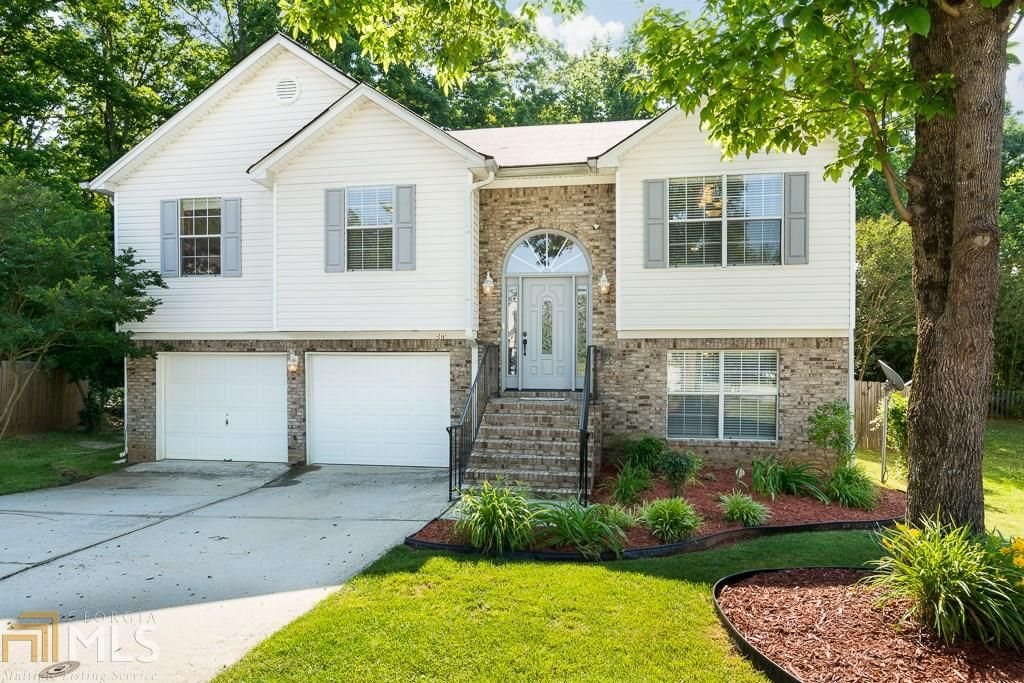 A two-story suburban house with a landscaped front yard and a double garage.