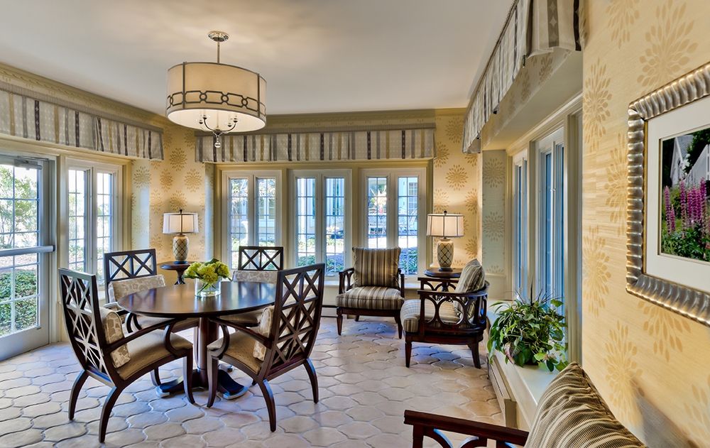A well-lit dining room with stylish furniture and large windows.