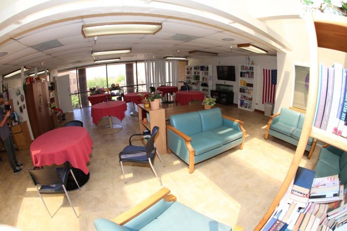 A spacious lounge area with sofas, tables, and a television.