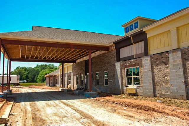 A photo of an unfinished building with a large entrance structure under clear blue skies.