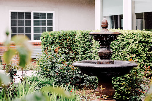 A serene garden scene featuring a classic fountain surrounded by lush greenery.
