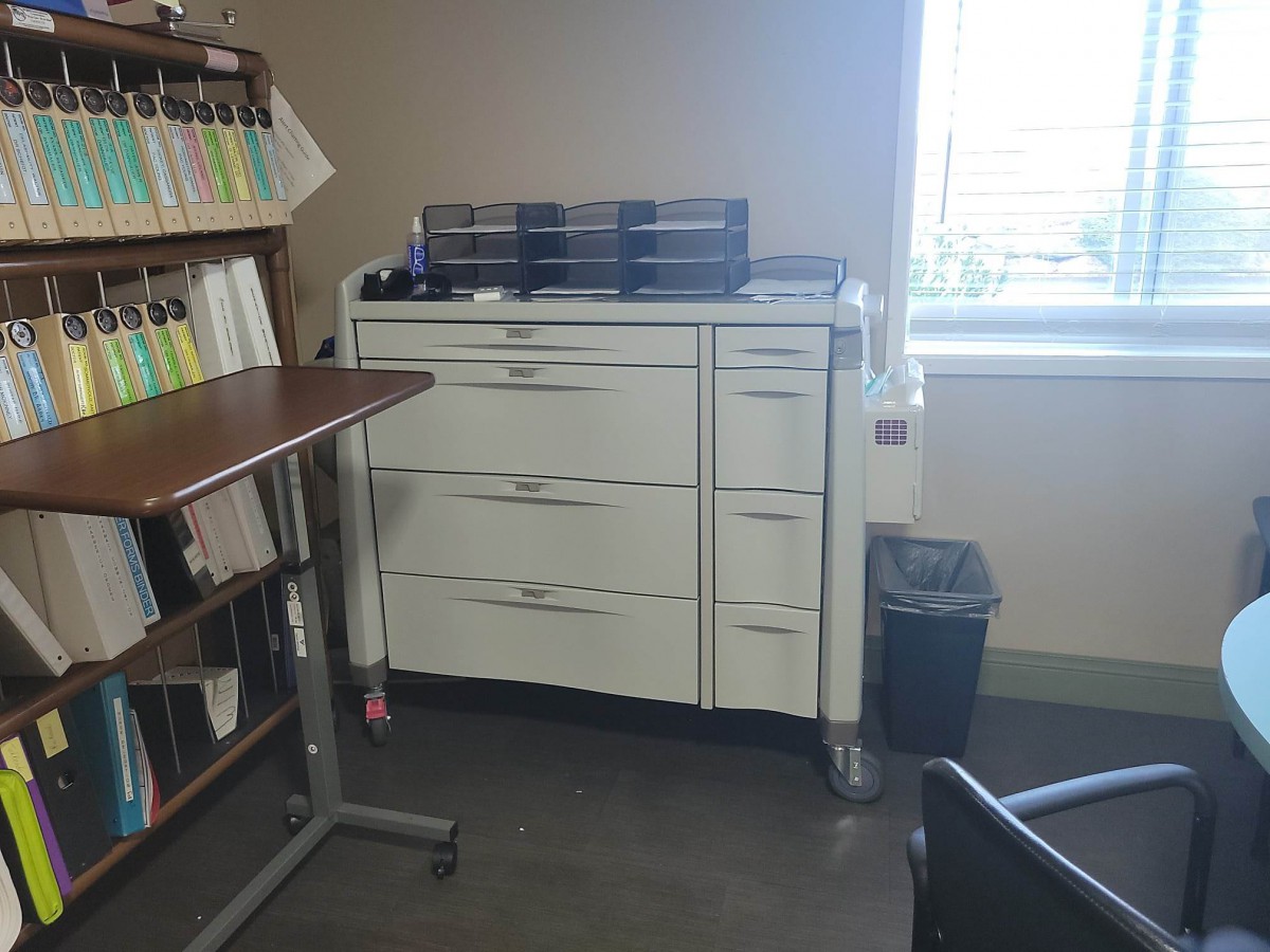 Office space with a cabinet and files near a window.