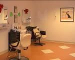 An empty hair salon with chairs and mirrors lined up, ready for clients.