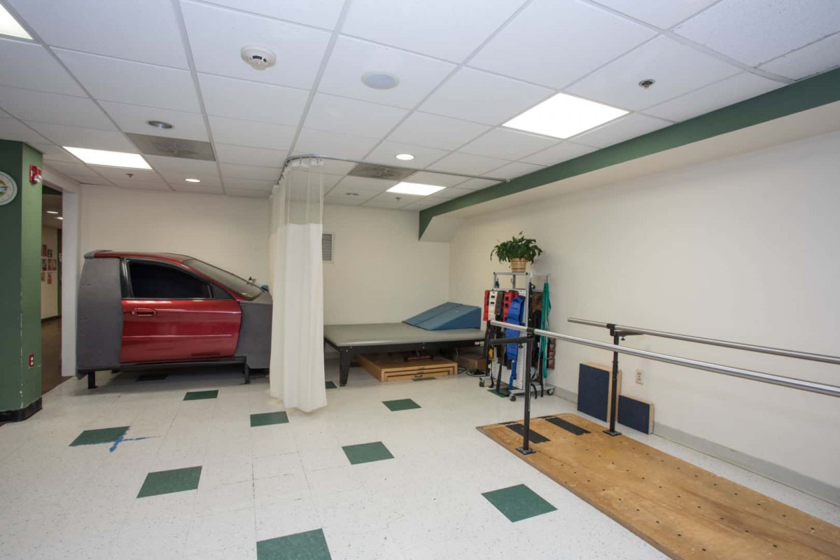 A physical therapy room equipped with a bed and various exercise equipment.