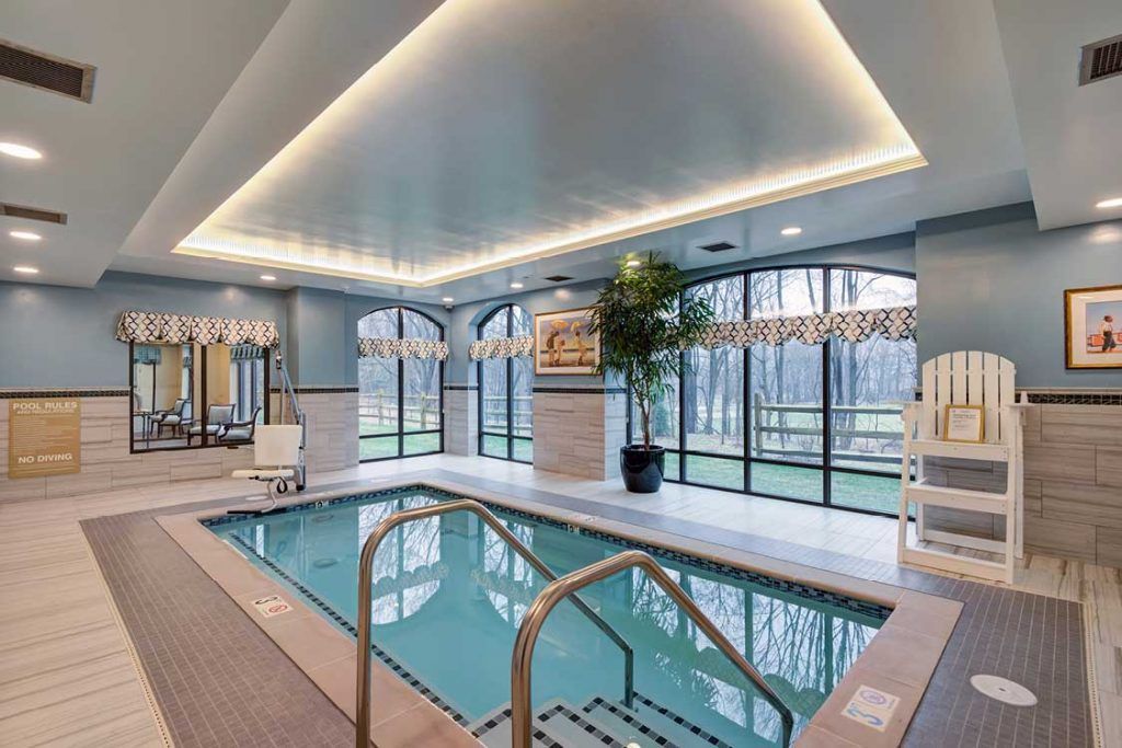 A luxurious indoor pool with large windows and modern design elements, perfect for relaxation.