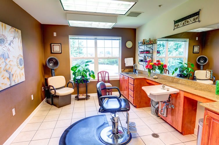A cozy and well-lit hair salon interior with a barber chair, mirror, and sink.