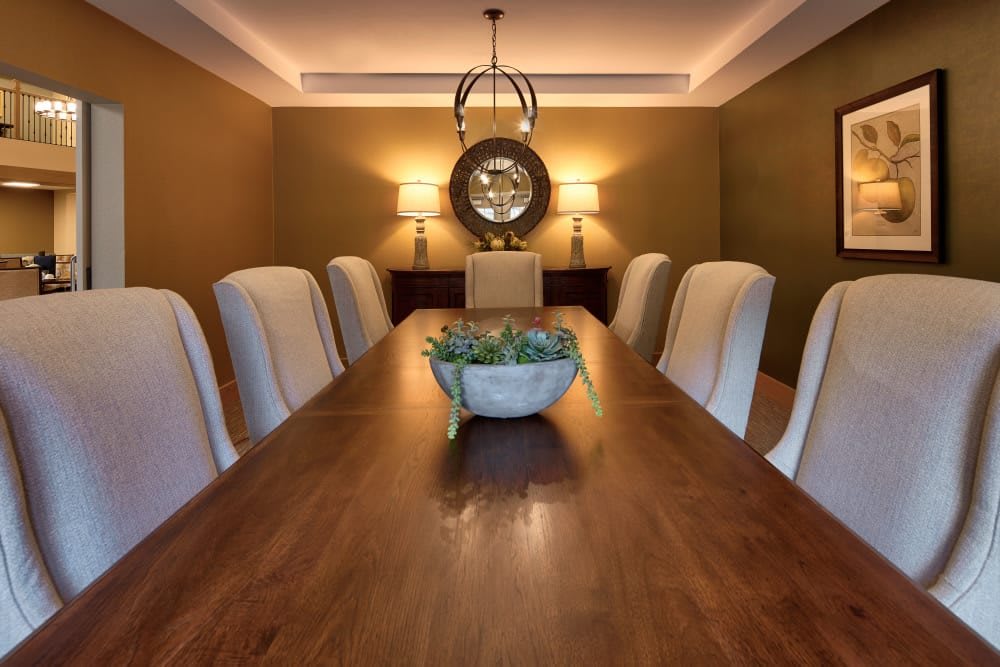 Elegant dining room with a long wooden table, comfortable chairs, and stylish lighting.