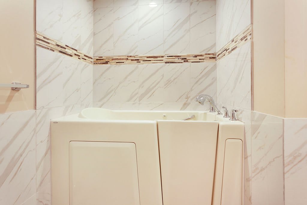 A spacious walk-in bathtub in a tiled bathroom setting.
