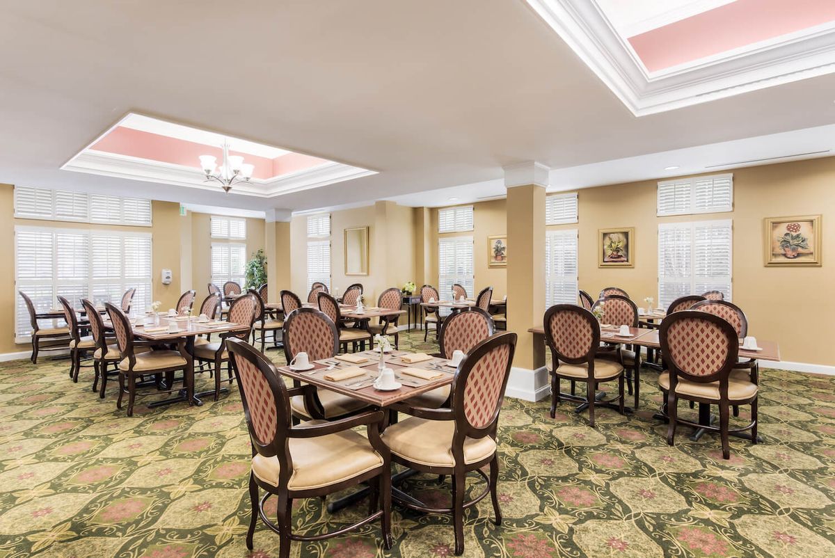 A well-furnished dining area with elegant seating and table settings.