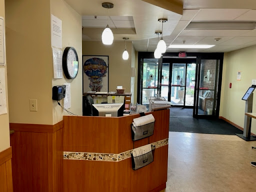 A welcoming reception area featuring a wooden front desk and modern lighting.