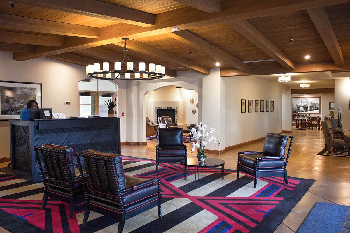 A modern lobby featuring stylish furniture and a prominent chandelier.