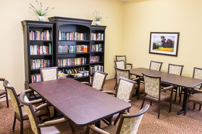 A library meeting room with bookshelves, tables, and chairs.