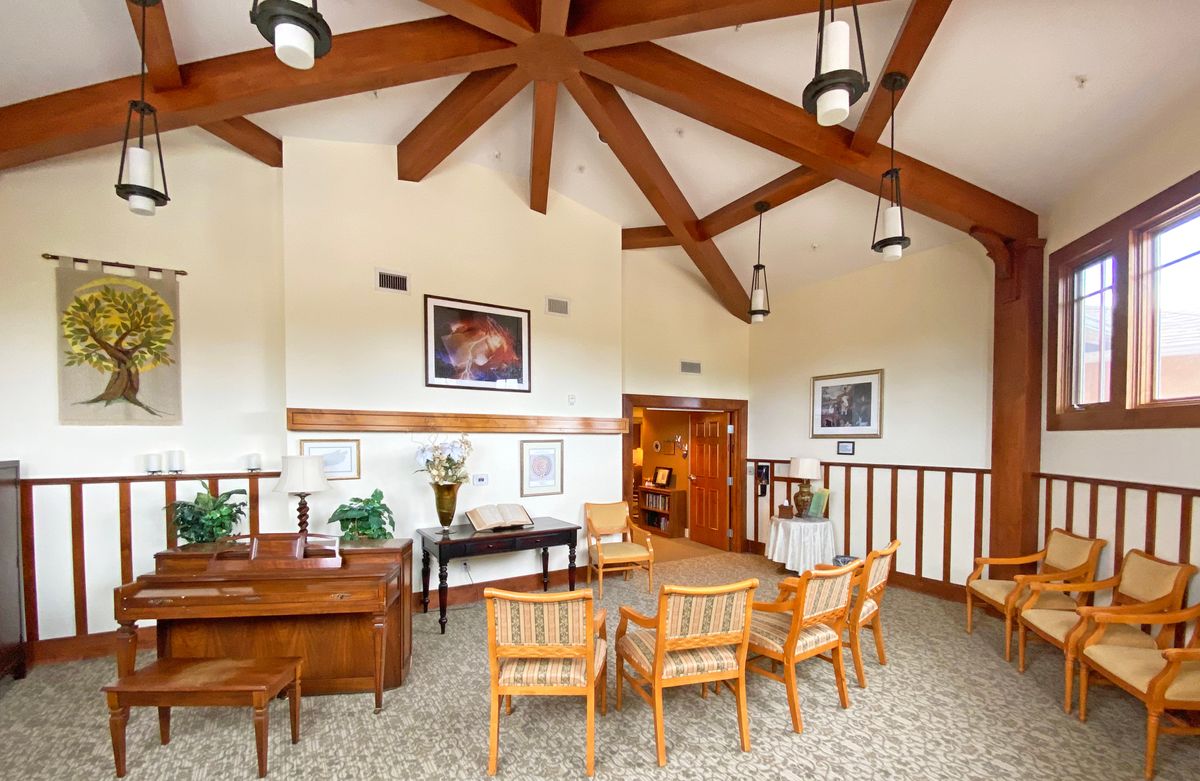 A cozy waiting room with wooden beams, comfortable chairs, and warm lighting.