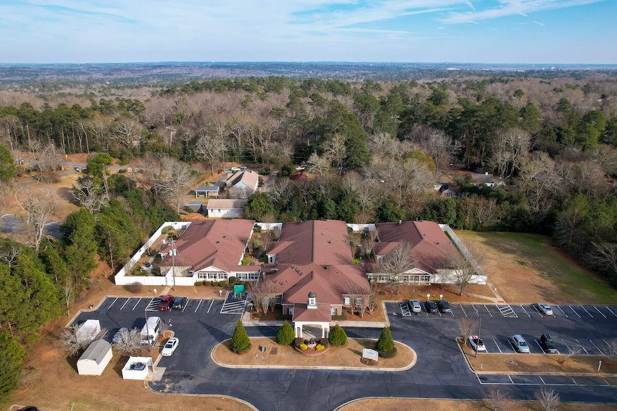 An aerial view of a complex with multiple buildings surrounded by trees.