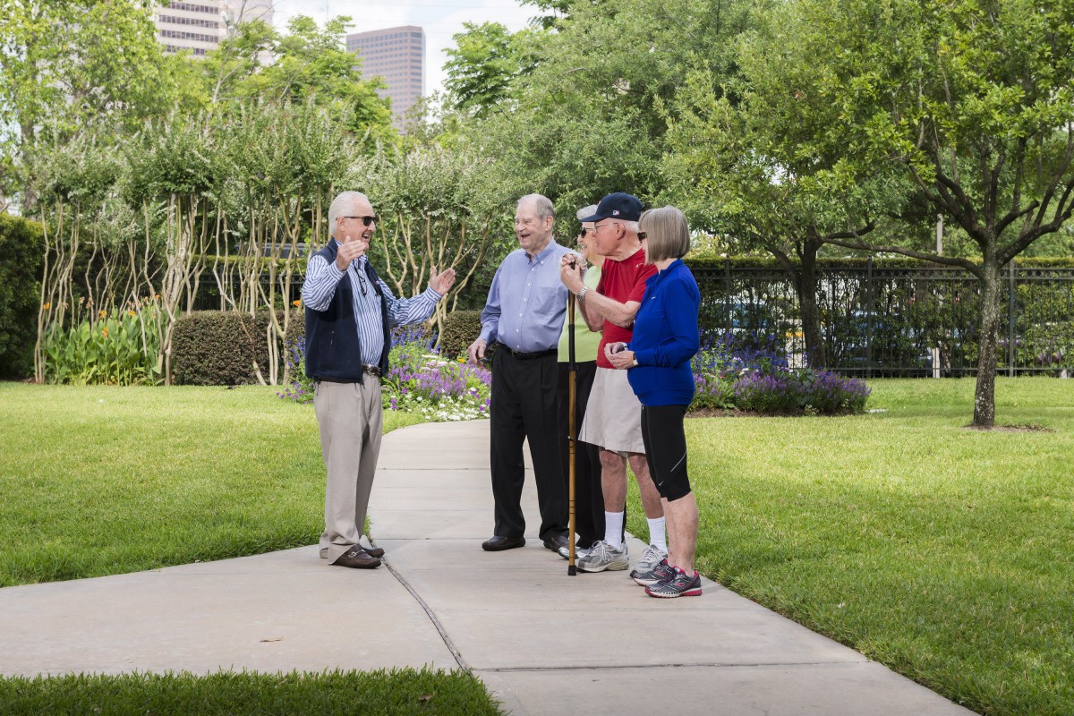 A group of people enjoying a conversation in a park on a pleasant day.