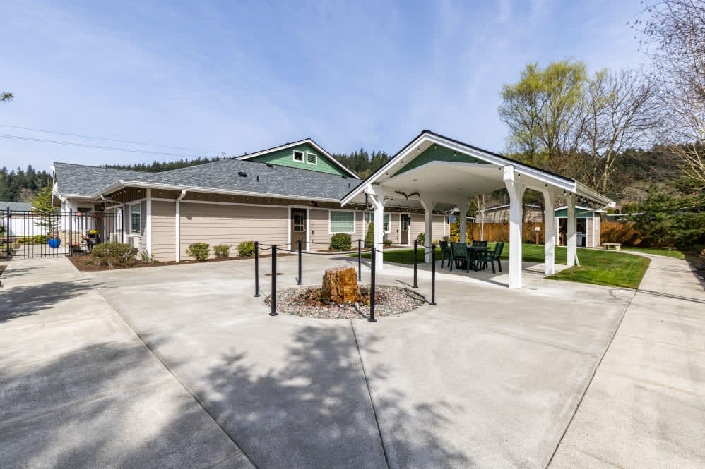 A picturesque view of a house exterior with a gazebo and clear skies.