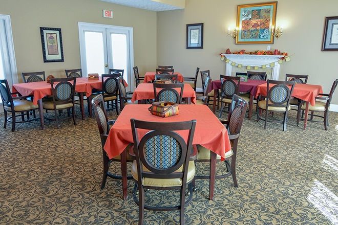A cozy dining room with tables covered in red tablecloths.