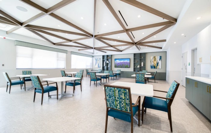 A modern dining area with stylish furniture and geometric ceiling design.