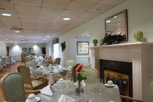 A beautifully arranged dining room featuring elegant tables and floral decorations, creating a warm and inviting atmosphere.