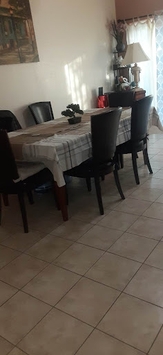A cozy dining area with a neatly set table and black chairs.