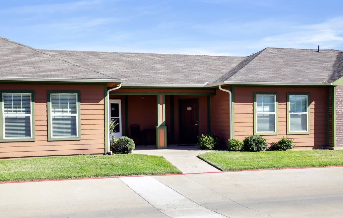 A suburban home with a front porch and neatly trimmed lawn.