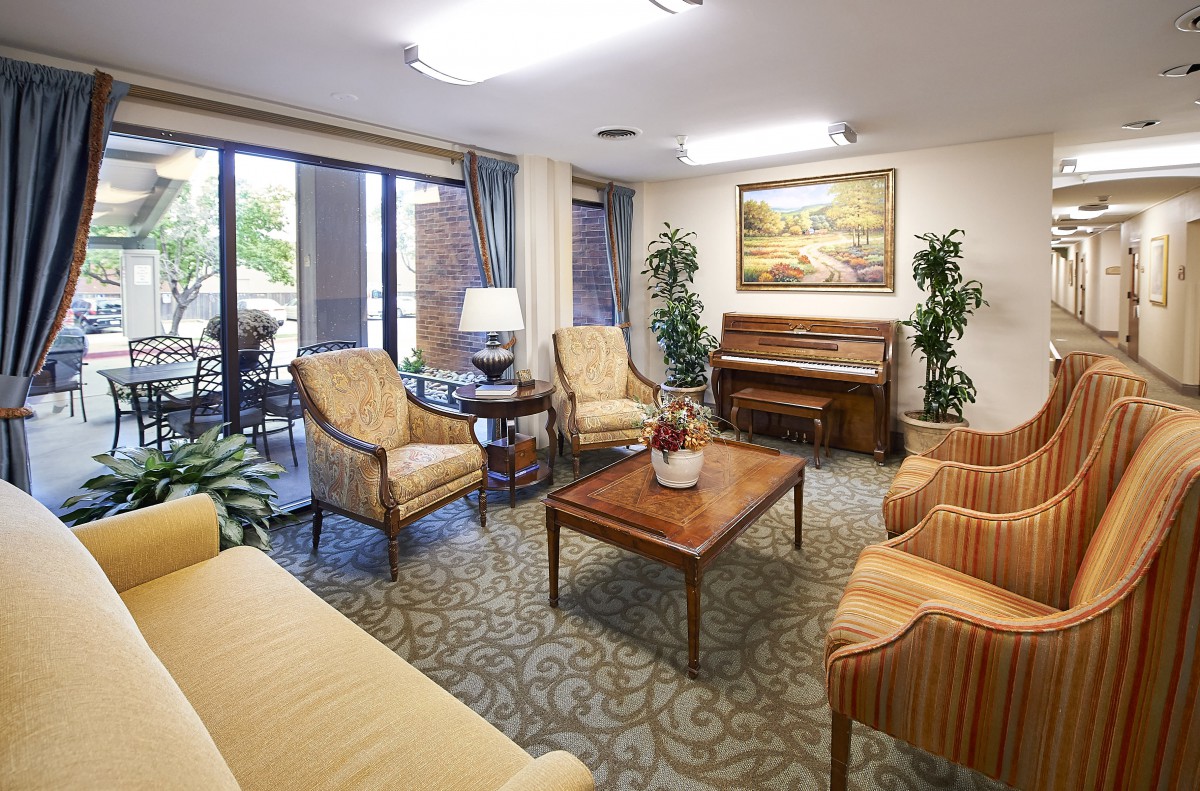 A cozy living room featuring comfortable seating, a piano, and elegant decor.