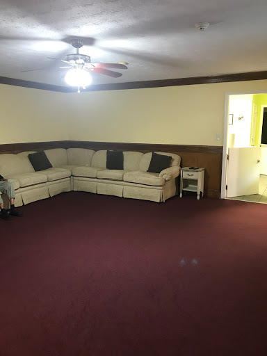 A spacious living room featuring a cozy corner sofa and warm yellow walls.