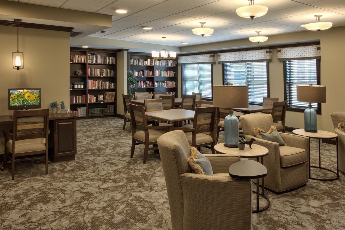 A cozy reading room with shelves full of books and comfortable seating.