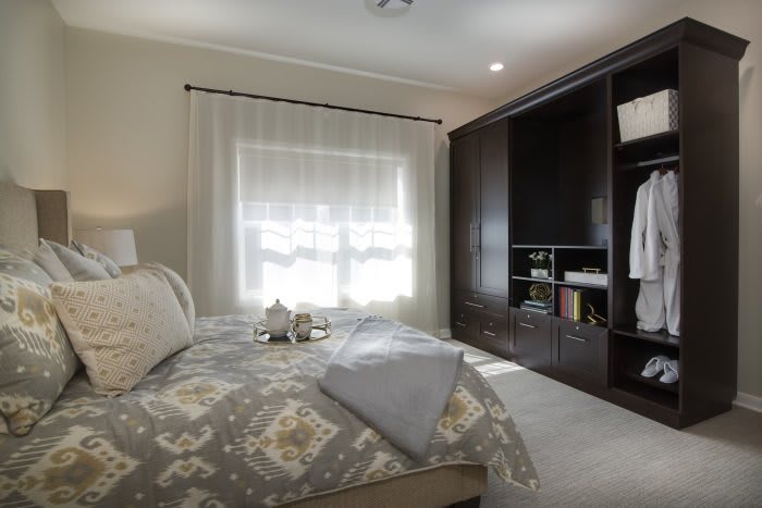 A cozy bedroom with elegant decor and ample storage.