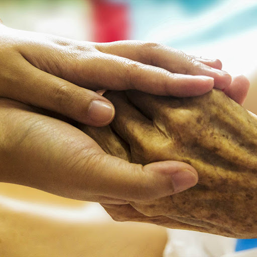 A moment of care and support, as one hand gently holds another.