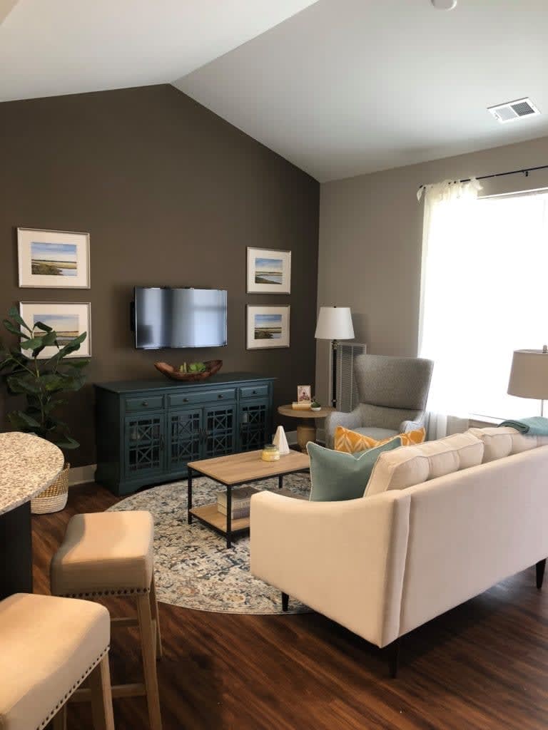 A modern living room with a cozy sofa, wall-mounted TV, and elegant decor.