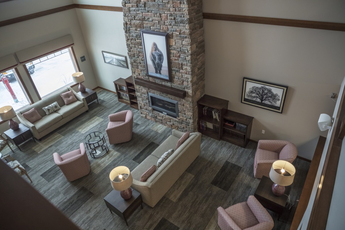 A spacious living room with a stone fireplace, cozy seating arrangements, and stylish interior design.