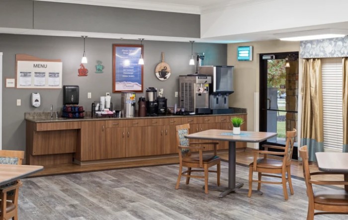 A cozy coffee station with wooden furniture and a seating area in an inviting interior setting.