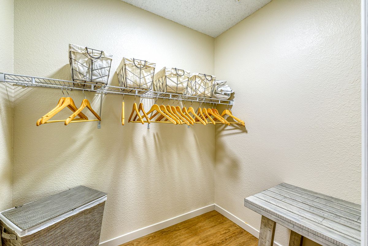 A neatly organized walk-in closet with hangers and storage baskets.
