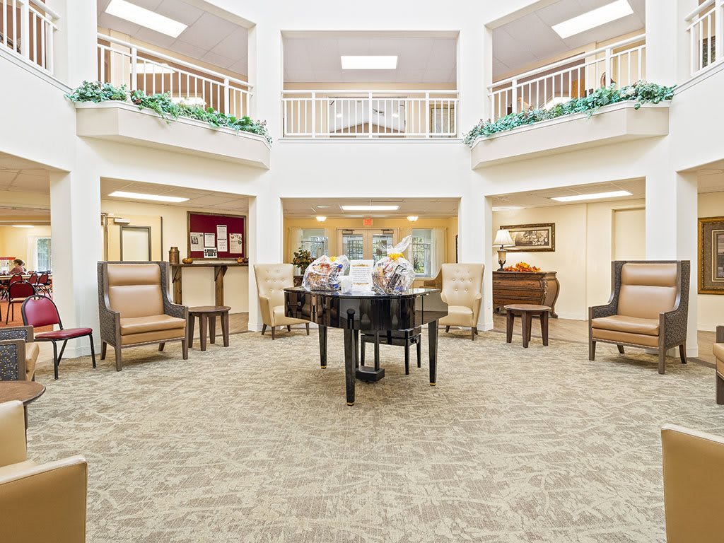 Spacious lobby with a central piano and comfortable seating.