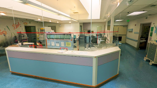 A view of a hospital reception area featuring a modern design and medical equipment.