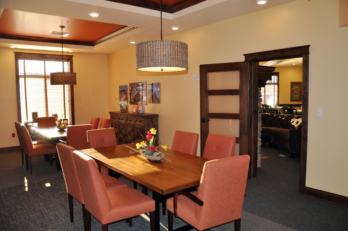 A well-decorated dining room featuring a wooden dining table, upholstered chairs, and a stylish chandelier.