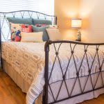 A cozy bedroom with a well-decorated bed and soft lighting.