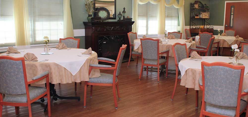 A cozy dining room with neatly arranged tables and chairs, featuring elegant decor.